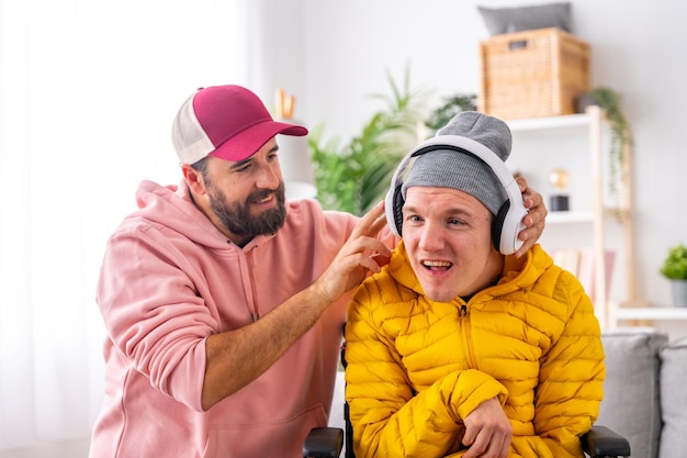 Gehandicapte man met koptelefoon luisteren naar muziek met vriend