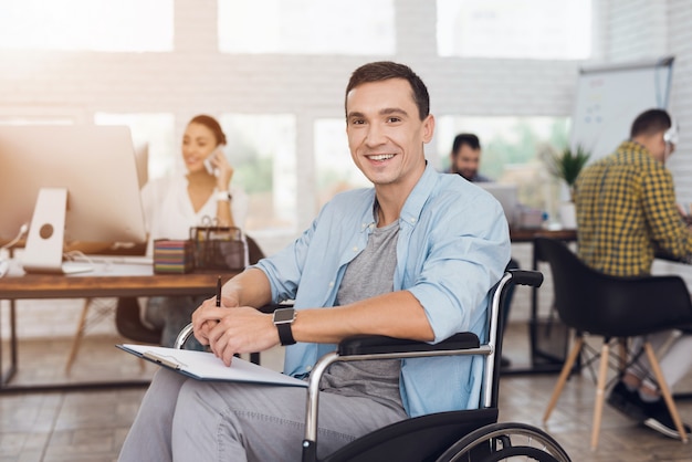 Gehandicapte man op rolstoel met tablet in office.