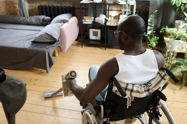 Gehandicapte man schoonmaak kamer met stofzuiger