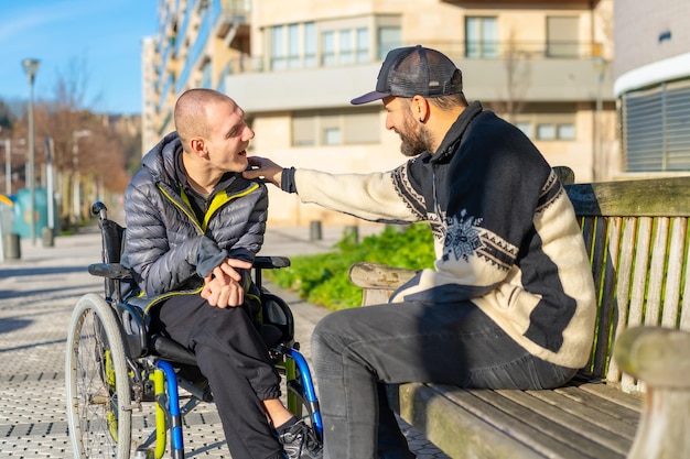 Gehandicapte persoon in een rolstoel met een vriend die plezier heeft en praat