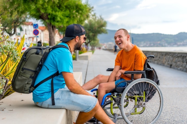 Gehandicapte persoon in rolstoel met vrienden op zomervakantie die plezier hebben