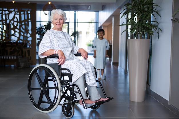 Gehandicapte senior patiënt op rolstoel in ziekenhuisgang