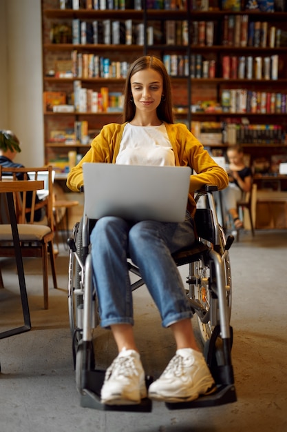 Gehandicapte student in rolstoel werkt op laptop