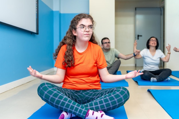 Gehandicapte vrouw in lotuspositie tijdens een yoga les