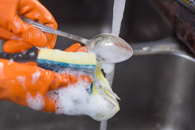 gehandschoende hand, een lepel wassen