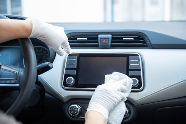 Gehandschoende handen die een auto schoonmaken