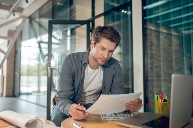 Geïnteresseerde man aan het werk op bouwplan