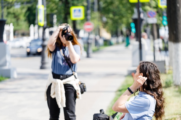 Geïnteresseerde vrouwelijke fotograaf die op straat werkt Buitenfoto van vrouwelijke fotograaf met camera