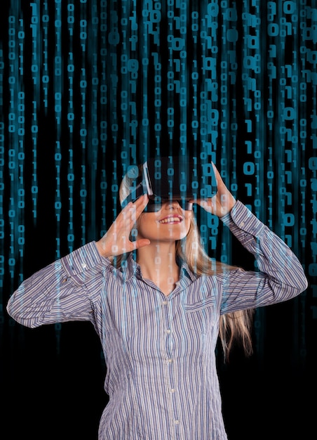 Geïntrigeerde vrouw die virtual reality 3D-headset draagt en het spel op zwarte achtergrond verkent