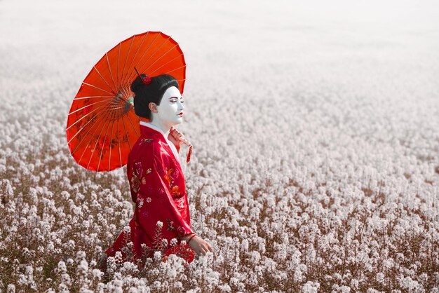 Foto geisha con ombrello rosso