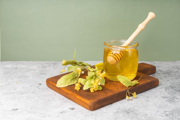 Geïsoleerd Honingbij in glazen pot en met honingsdipper op witte achtergrond