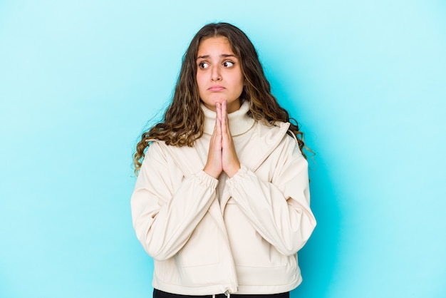 Geïsoleerd jonge blanke vrouw met krullend haar bidden, toewijding tonen, religieuze persoon op zoek naar goddelijke inspiratie.