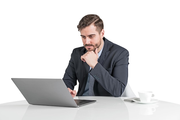 Geïsoleerd portret van serieuze jonge zakenman met baard die werkt met een laptopcomputer aan kantoortafel. Concept van kantoorwerk.