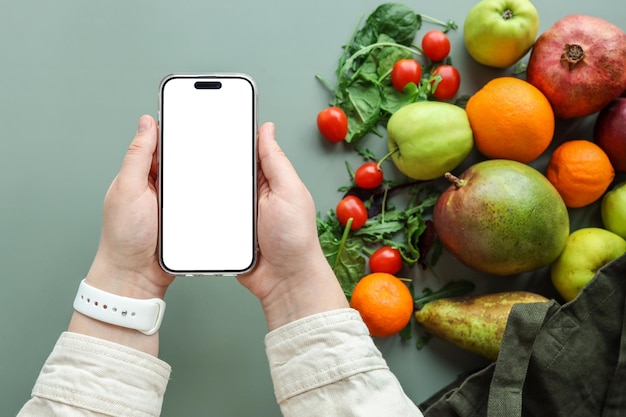 Geïsoleerd telefoonscherm in handen en app voor gewichtsverlies van verse groenten en fruit