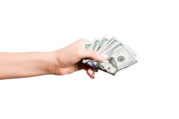 Geïsoleerde afbeelding van vrouwelijke hand met een bundel dollars op wit oppervlak