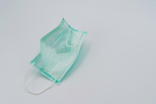 Geïsoleerde hygiënisch masker groene kleur in studiolicht op witte achtergrond