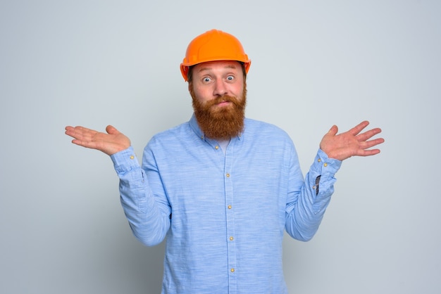 Geïsoleerde onzekere architect met baard en oranje helm