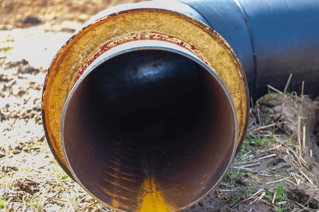 Geïsoleerde pijp Grote metalen pijpen met een plastic omhulsel op een bouwplaats Moderne pijpleiding voor het leveren van warm water en verwarming aan een woonwijk Close-up