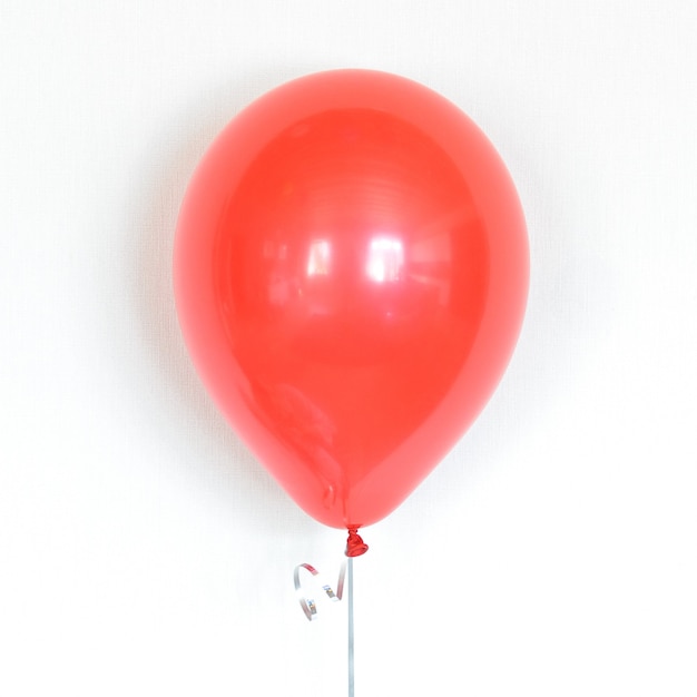 Foto geïsoleerde rode heliumballon drijvend