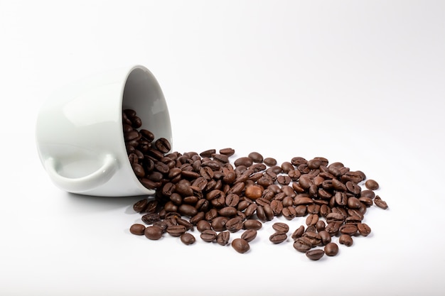 Geïsoleerde witte kop met koffiebonen