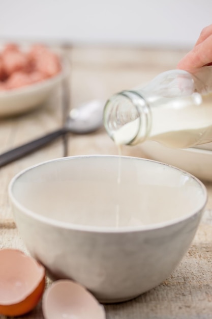 Gekapte afbeelding van een hand die melk in een schaal giet