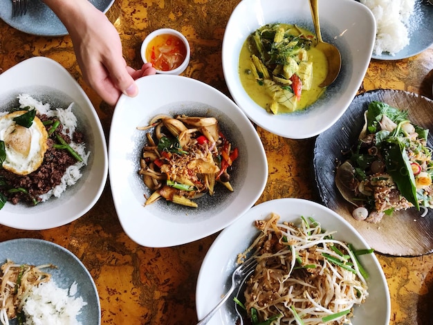 Gekapte afbeelding van een hand die tijdens de lunch voedsel in een schaal vasthoudt