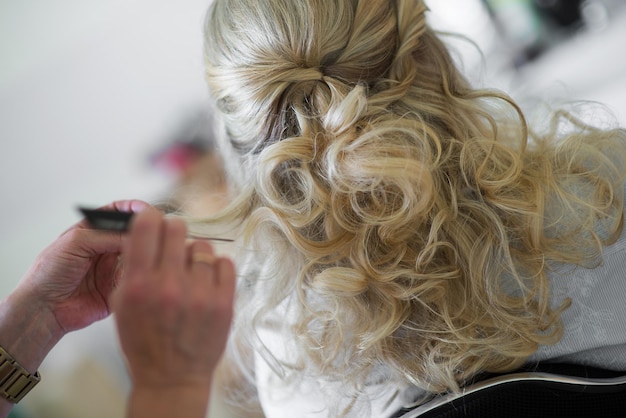 Gekapte afbeelding van een kapper die het haar van een klant in een salon stylt