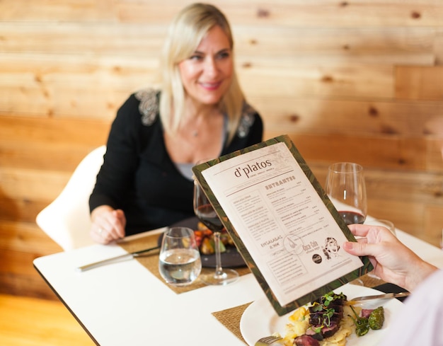 Foto gekapte afbeelding van een man met een menu in een restaurant