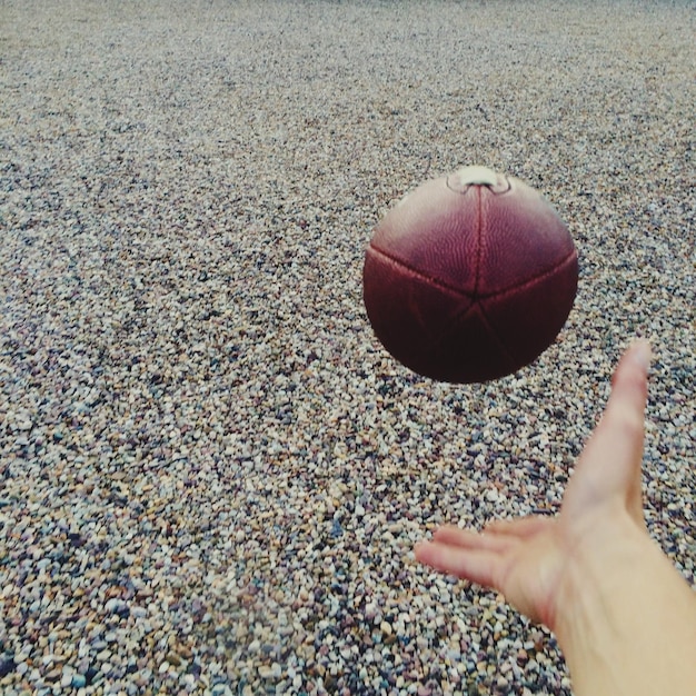 Foto gekapte afbeelding van een persoon die amerika football speelt op het strand