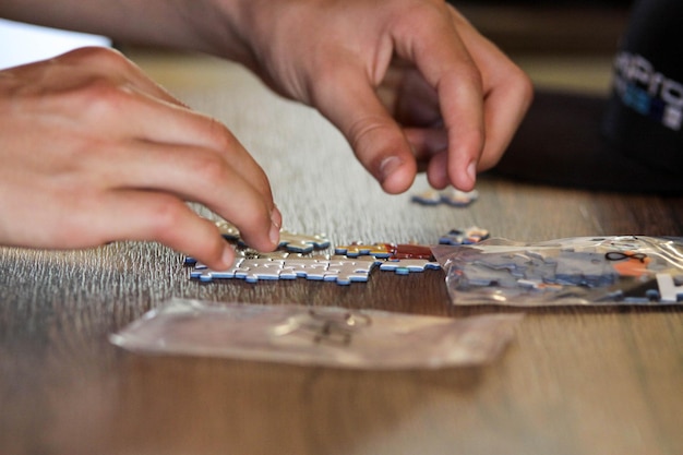 Foto gekapte afbeelding van een persoon die met een puzzel op tafel speelt