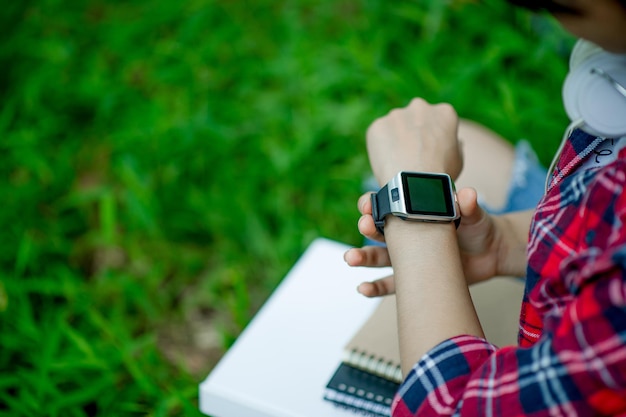 Foto gekapte afbeelding van een vrouw die een slim horloge draagt in het park