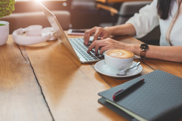 Gekapte afbeelding van een zakenvrouw met een laptop aan een restauranttafel