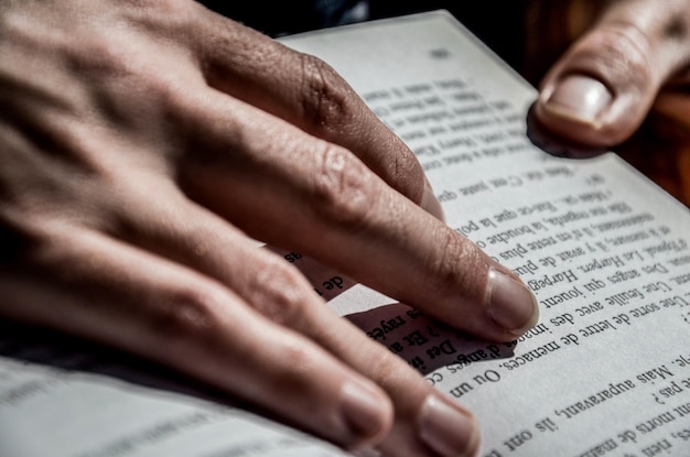 Gekapte afbeelding van handen die een boek vasthouden