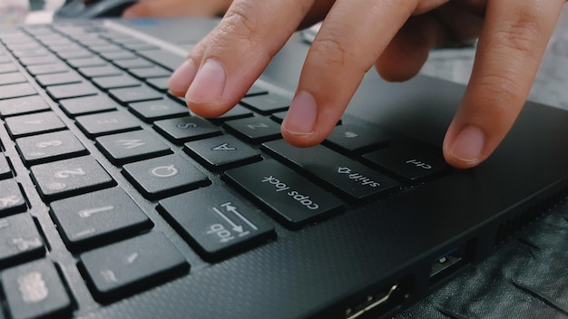 Gekapte afbeelding van persoon die laptop gebruikt