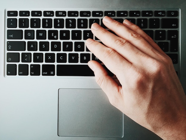 Gekapte afbeelding van persoon die laptop gebruikt