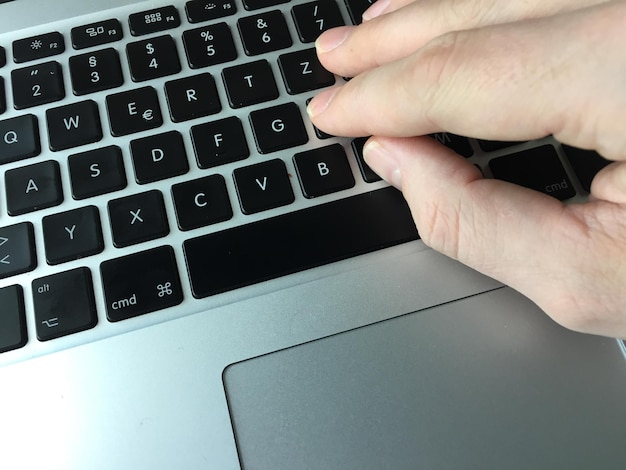 Gekapte afbeelding van persoon die laptop gebruikt