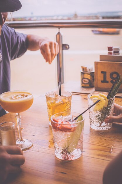 Foto gekapte afbeelding van vrienden die drankjes drinken op tafel in een restaurant
