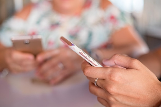Gekapte afbeelding van vrouwen die een mobiele telefoon gebruiken