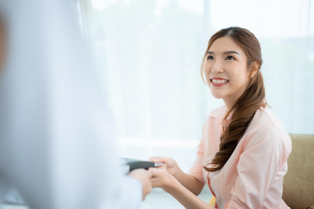 Gekapte foto van een vrouw die met een creditcard betaalt in de VIP-zaal van de winkel.