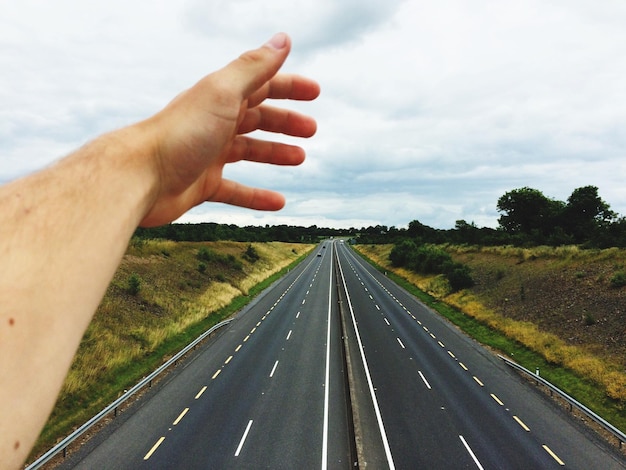 Foto gekapte hand boven een snelweg met twee rijstroken.