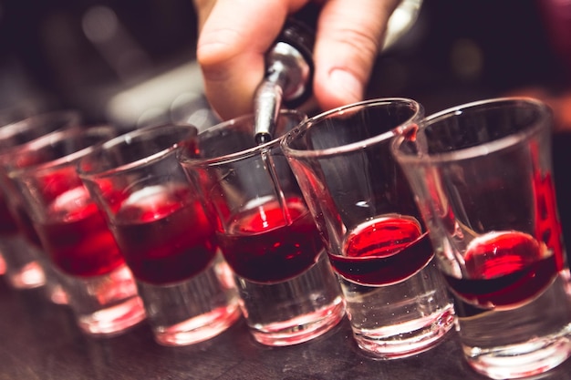 Gekapte hand die cocktail maakt op de bar.