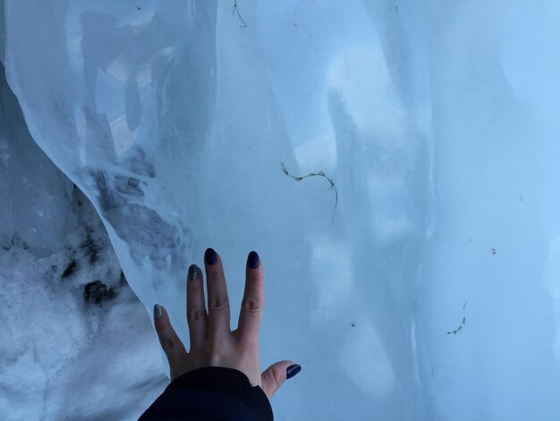 Foto gekapte hand die ijs aanraakt