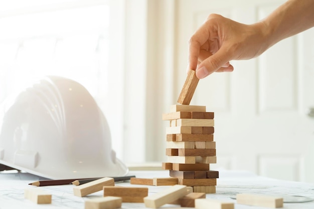 Gekapte hand die met houten speelgoedblokken aan tafel speelt