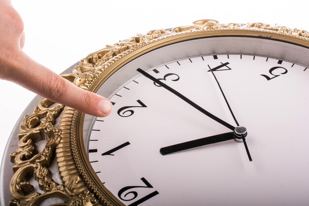 Foto gekapte hand die op een horloge gebaar doet tegen een witte achtergrond