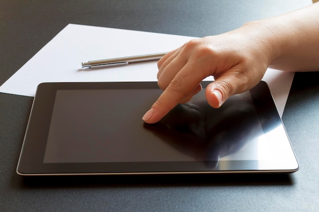 Foto gekapte hand met behulp van een digitale tablet op tafel