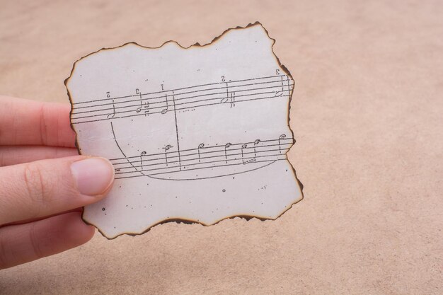 Foto gekapte hand met bladmuziek aan tafel