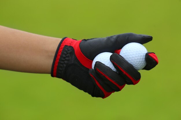 Foto gekapte hand met golfballen op de baan