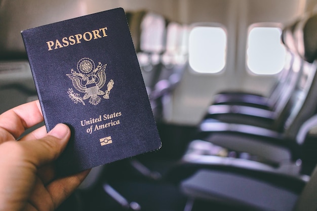 Gekapte hand met paspoort in het vliegtuig