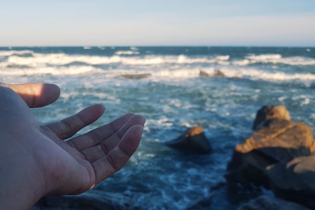 Foto gekapte hand tegen de zee