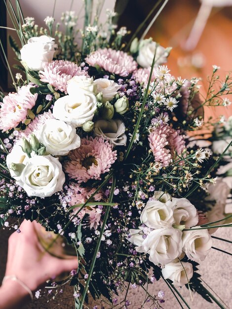 Gekapte hand van een persoon die een boeket bloemen vasthoudt